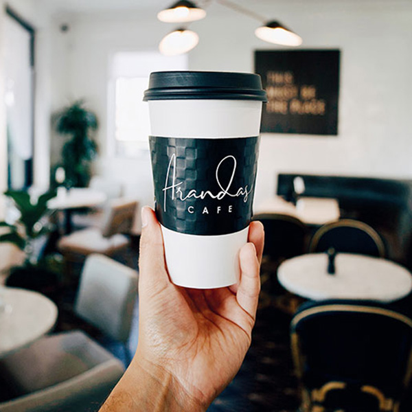 Amandas Cafe cup in front of open sign